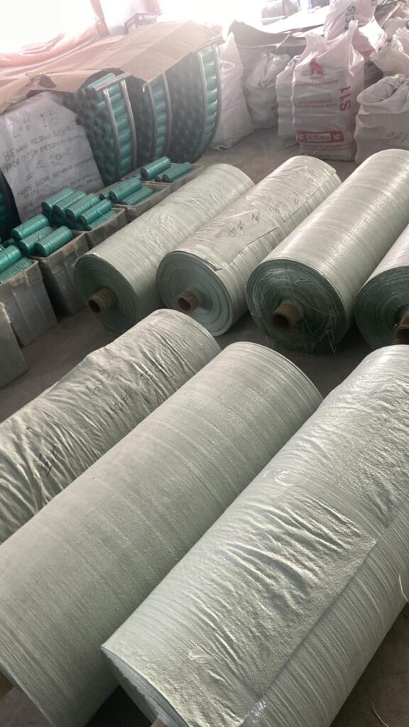 Gulungan bahan baku plastik dan benang untuk produksi karung goni